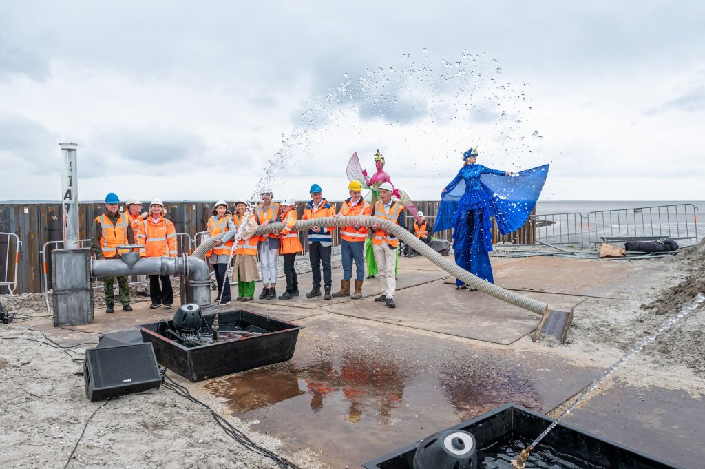 Partners van de natuurprojecten voeren samen de starthandeling uit op de dijk