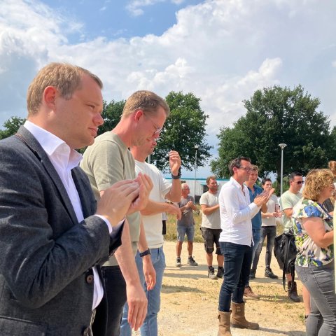 Toekomstig bewoners CPO Grasheim en wethouder Michel Graef vieren bereiken hoogste punt
