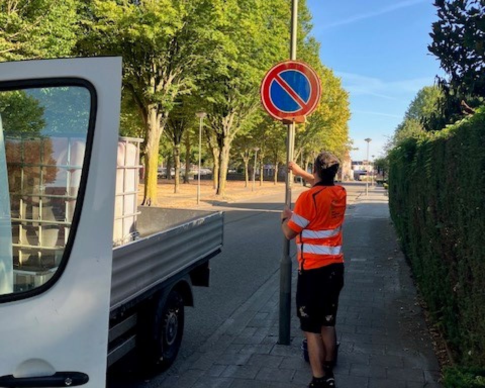 A MOB employee puts up a traffic sign
