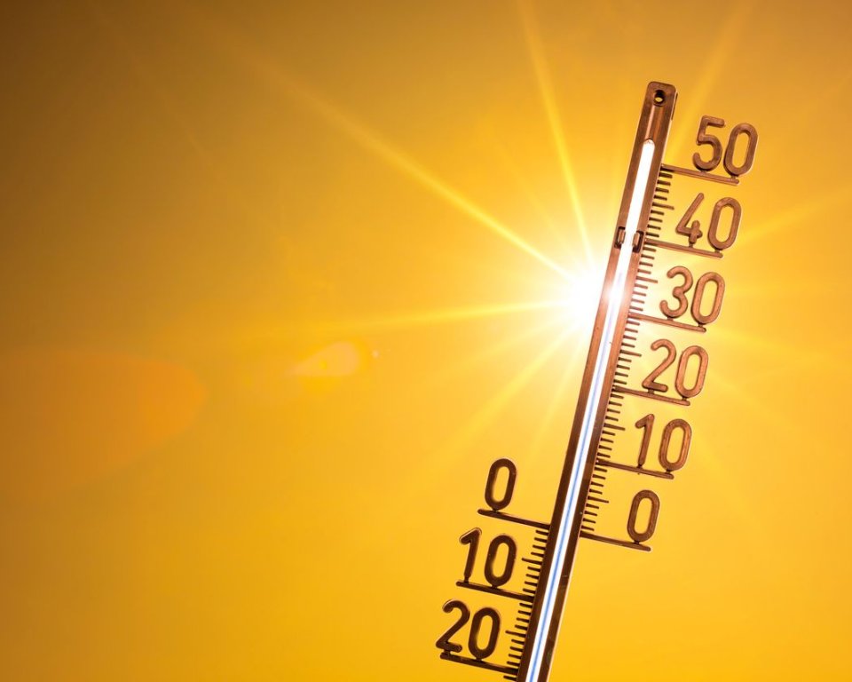 Thermometer met zon op de achtergrond