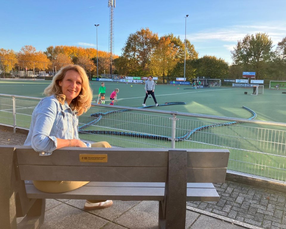 Foto van voorzitter Elsbeth van der Hoeven op het bankje met het plaatje van 113 Zelfmoordpreventie.