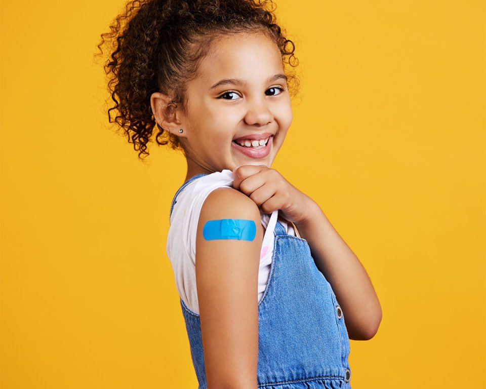 Foto van een meisje met een pleister van de vaccinatie. Foto ter illustratie. 