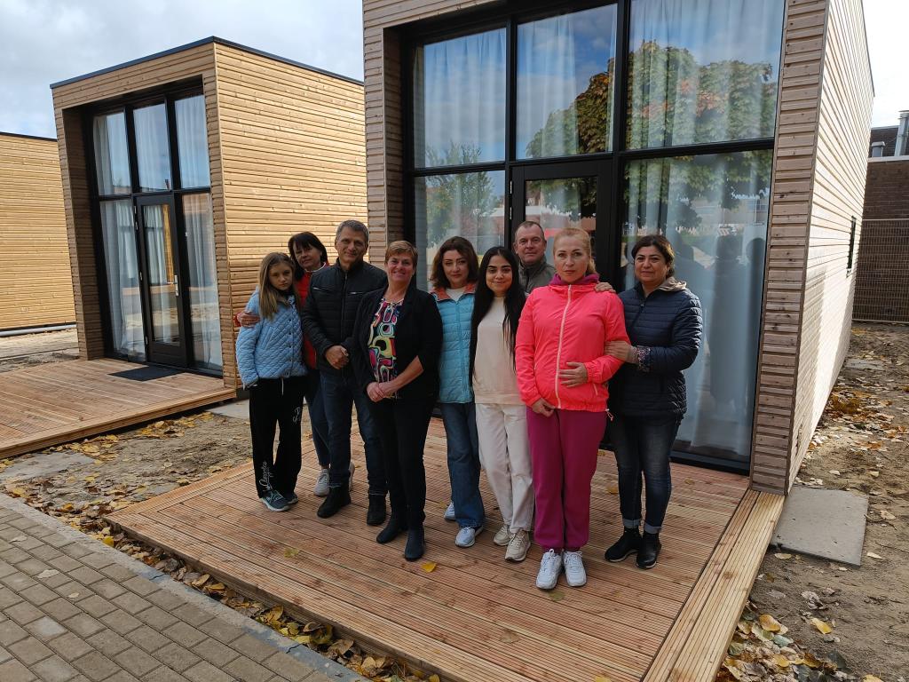 Burgemeester Kalfs samen met bewoners voor de tiny houses