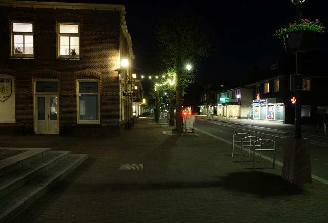 Straatbeeld met verlichte etalages waardoor de openbare verlichting wegvalt