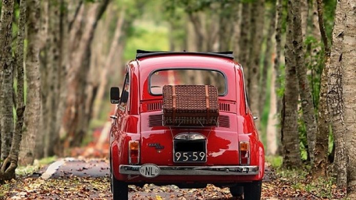 Rode Fiat500 met rieten koffertje achterop 