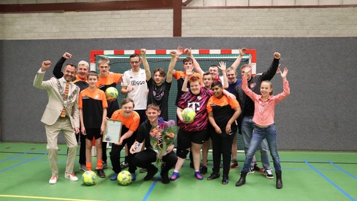 Winnaar Thijmen Schimmel met zaalvoetballers, burgemeester, kinderburgemeester, jongerenwerker en mevrouw Müller van Omnisport