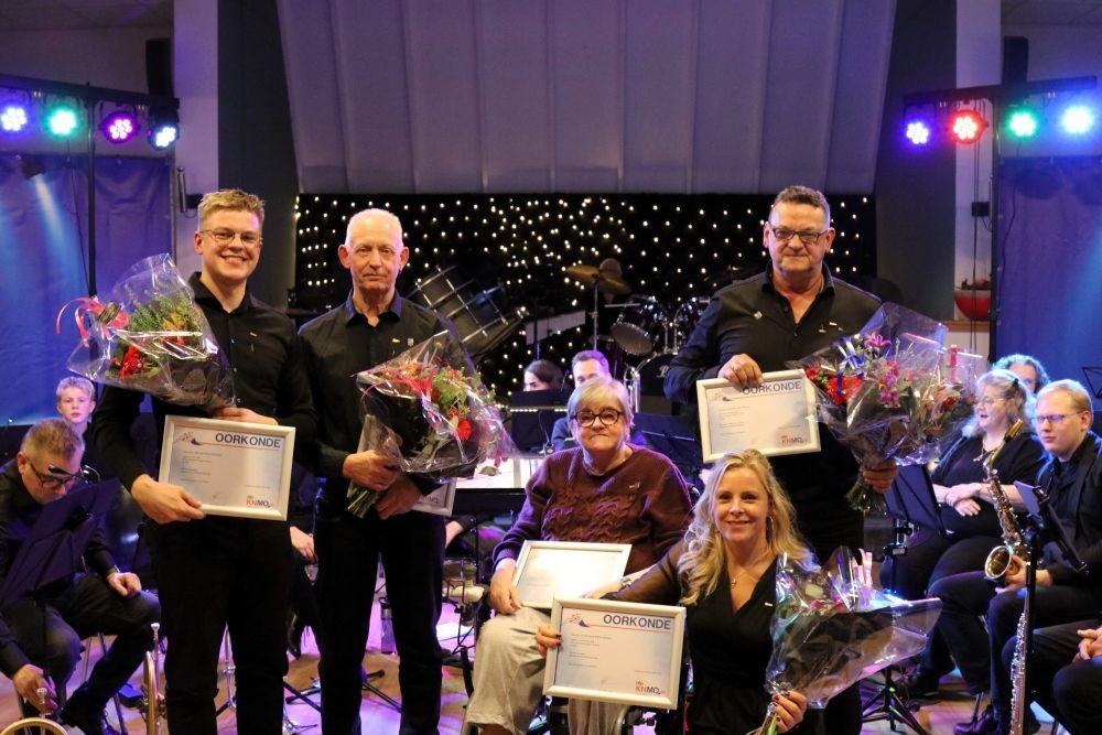 De jubilarissen met erespelden, insignes, oorkondes en bloemen