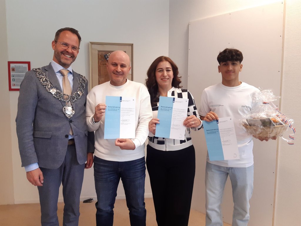 Burgemeester Laurens de Graaf met familie Altaki en hun Bewijs van Nederlanderschap