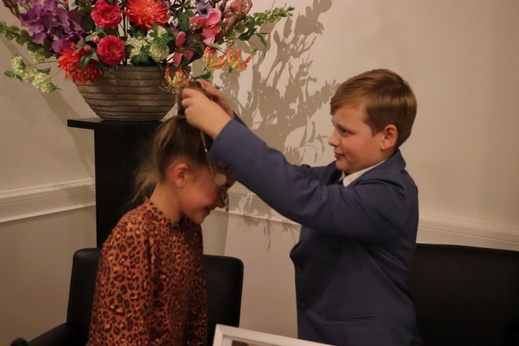 Justin den Uil hangt de ambtsketen om bij Hannah van Ee