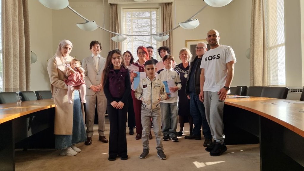 Inwoners die de Nederlandse nationaliteit verkregen samen met burgemeester Renate Westerlaken-Loos in de raadzaal