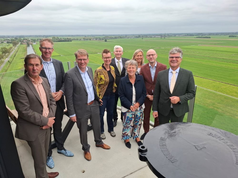 Colleges van Gedeputeerde Staten en gemeente Lopik op de watertoren met uitzicht over de polder
