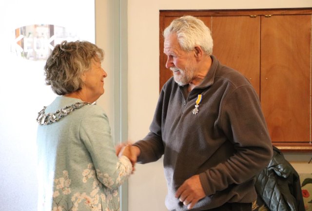 Burgemeester Renate Westerlaken-Loos spelt Koninklijke onderscheiding op bij de heer Jan Noorlandt