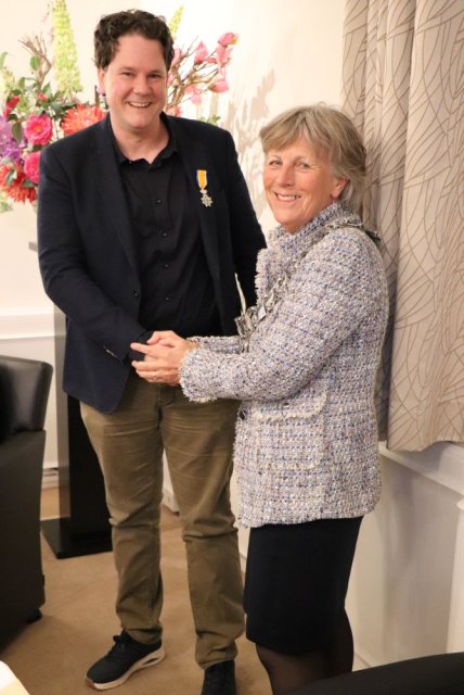 Burgemeester Renate Westerlaken-Loos feliciteert de heer Nick Kramer met zijn Koninklijke onderscheiding