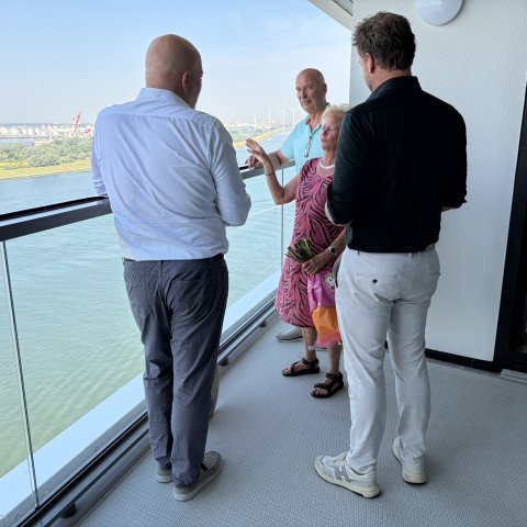 Wethouder Robert Simons met de nieuwe bewoners van de laatste woning in Het Baken tijdens de sleuteloverdracht. Met deze oplevering is de ontwikkeling van Het Balkon van Maassluis aan de Nieuwe Waterweg afgerond.