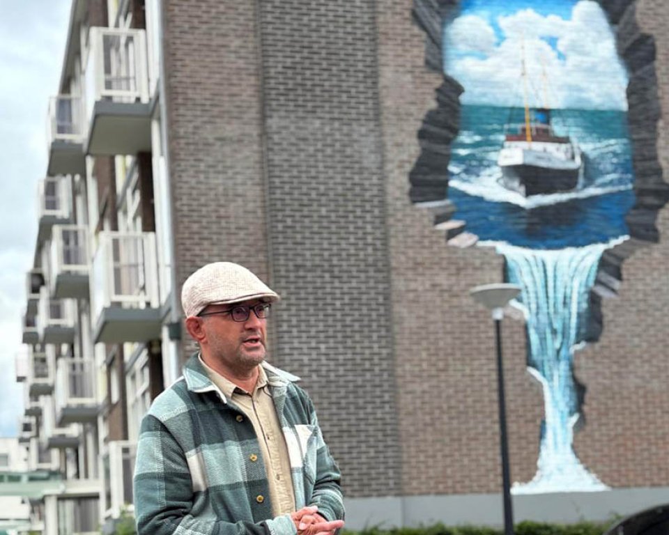 Foto van kunstenaar Rolf de Bakker bij mural Zwarte Zee