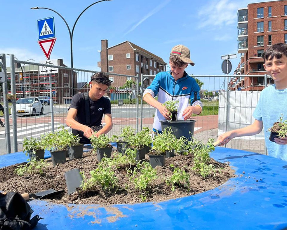 Foto van jongeren die helpen bij het vullen van het plantvak bij Palet