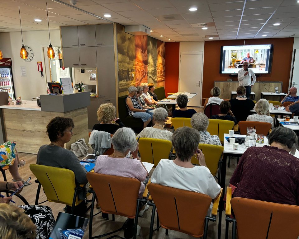De foto toont bewoners van Oud Sluys die deelnemen aan de interactieve bijeenkomst om digitale criminaliteit te kunnen herkennen en voorkomen. 
