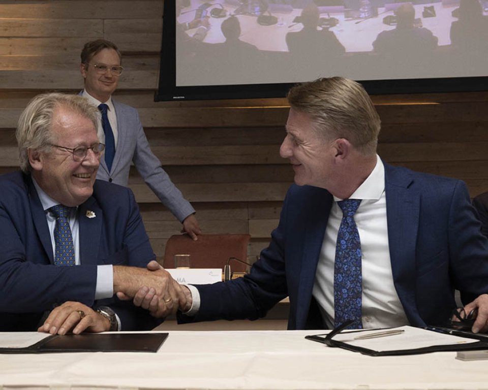 Foto van Commissaris van de Koning Jaap Smit die burgemeester Jack de Vries de hand schudt