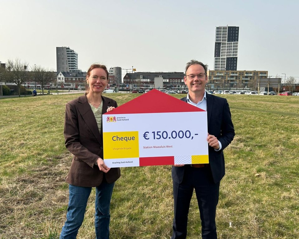 Gedeputeerde Anne Koning (links) overhandigt wethouder Sjoerd Kuiper (rechts) een bijdrage vanuit de provincie.