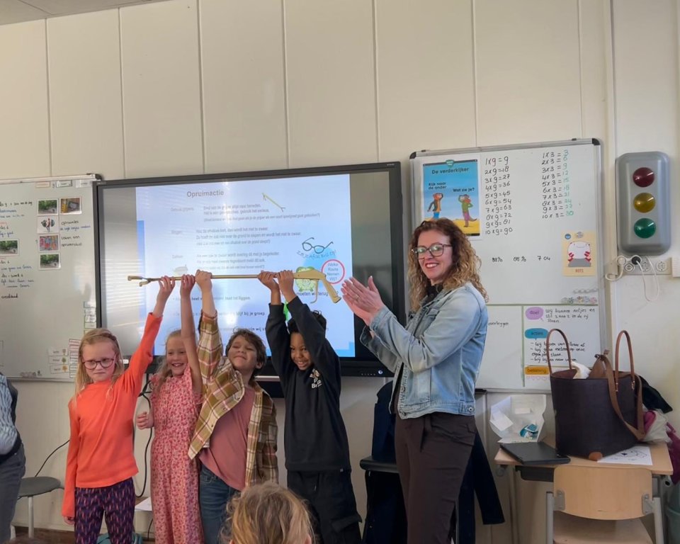 Wethouder Denise Mulder overhandigt de Gouden Grijper aan scholieren van IKC De Regenboog.