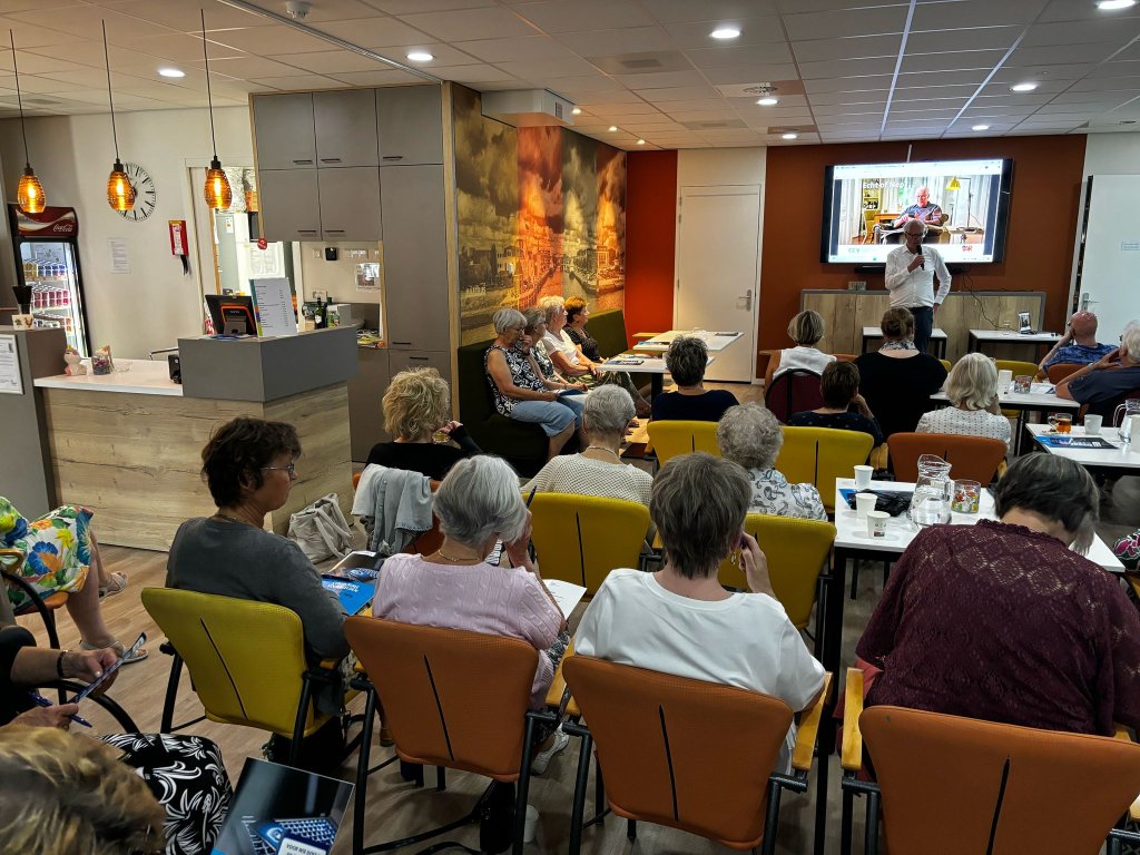 De foto toont bewoners van Oud Sluys die deelnemen aan de interactieve bijeenkomst om digitale criminaliteit te kunnen herkennen en voorkomen.