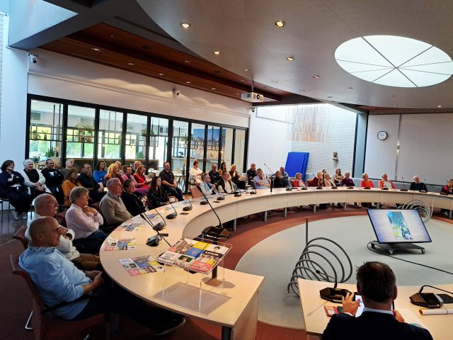 raadszaal met toehoorders tijdens aftrap Maand van de ontmoeting 