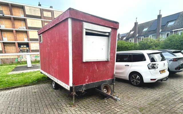 Foto van een rode aanhanger op een parkeerplaats aan De Génestetstraat