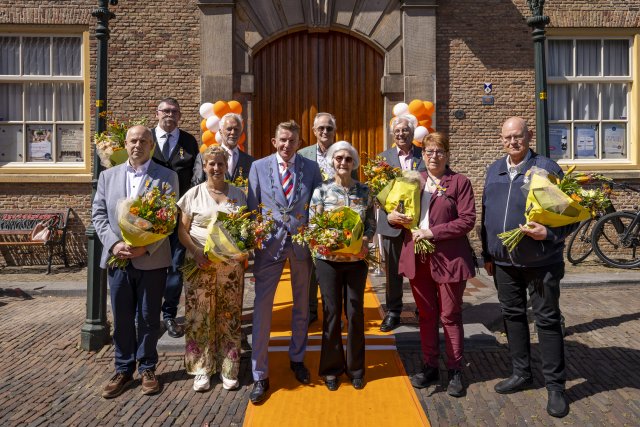 De gedecoreerden van de Lintjesregen 2026 samen met burgemeester Jack de Vries voor de Groote Kerk. Twee decorandi waren vandaag niet aanwezig.