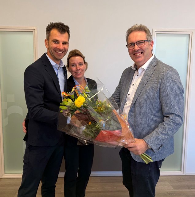 Coen van Woudenberg (rechts), clustermanager van de gemeente Maassluis, overhandigt bloemen aan Stefan Nitsche en Anouk de Konink van Toff Catering na de ondertekening van de samenwerkingsovereenkomst voor de catering in de vernieuwde aula van de Nieuwe Begraafplaats en het crematorium.