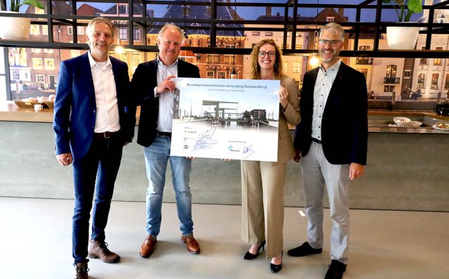 Wethouder Mulder en de drie directeur van Repontis tonen een vergrote afbeelding van de ondertekende bouwteamovereenkomst