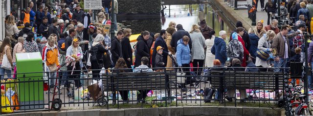 Foto van een drukbezochte kleedjesmarkt aan het begin van de Nieuwstraat