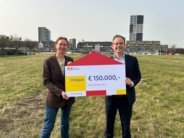 Gedeputeerde Anne Koning (links) overhandigt wethouder Sjoerd Kuiper (rechts) een bijdrage vanuit de provincie.