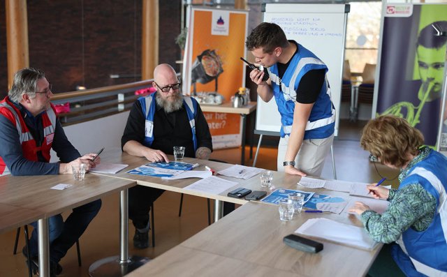 Foto van deelnemers aan de oefening die informatie uitwisselen en besluiten nemen zonder reguliere stroom- en dataverbindingen