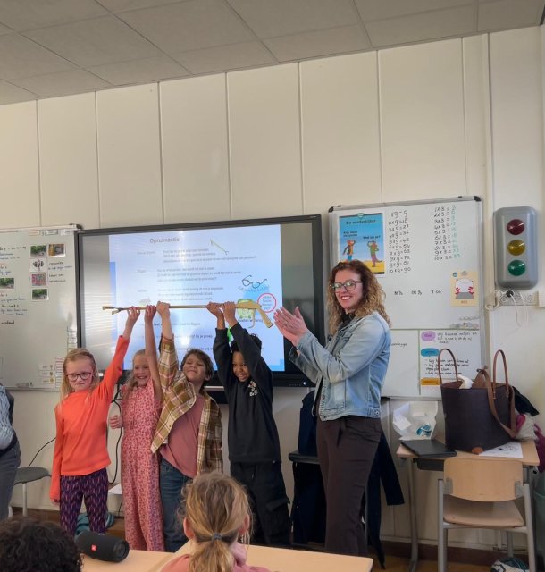 Wethouder Denise Mulder overhandigt de Gouden Grijper aan scholieren van IKC De Regenboog. 