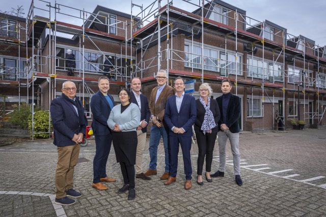 Wethouder Sjoerd Kuiper samen met vertegenwoordigers Maasdelta, Waterweg Wonen en huurdersorganisaties in de Steendijkpolder, waar in opdracht van Maasdelta wordt gewerkt aan groot onderhoud en verduurzaming van huurwoningen. 