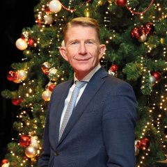 Foto van burgemeester De Vries voor een versierde kerstboom