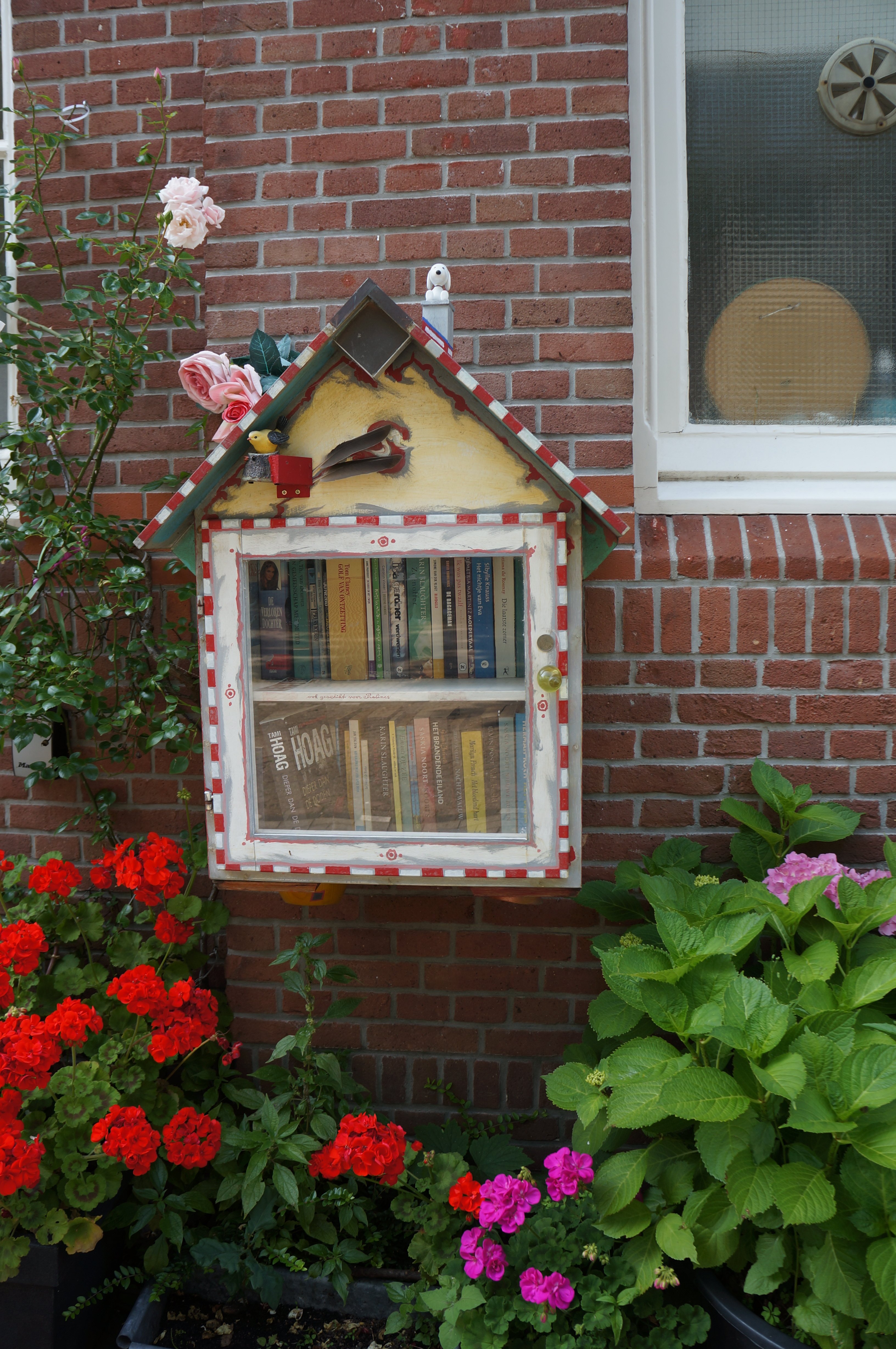 Boeken ruilkastje met vrolijke bloemen eromheen
