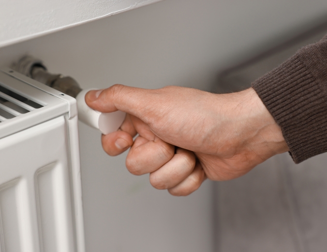 Hand die de verwarmingsknop lager zet