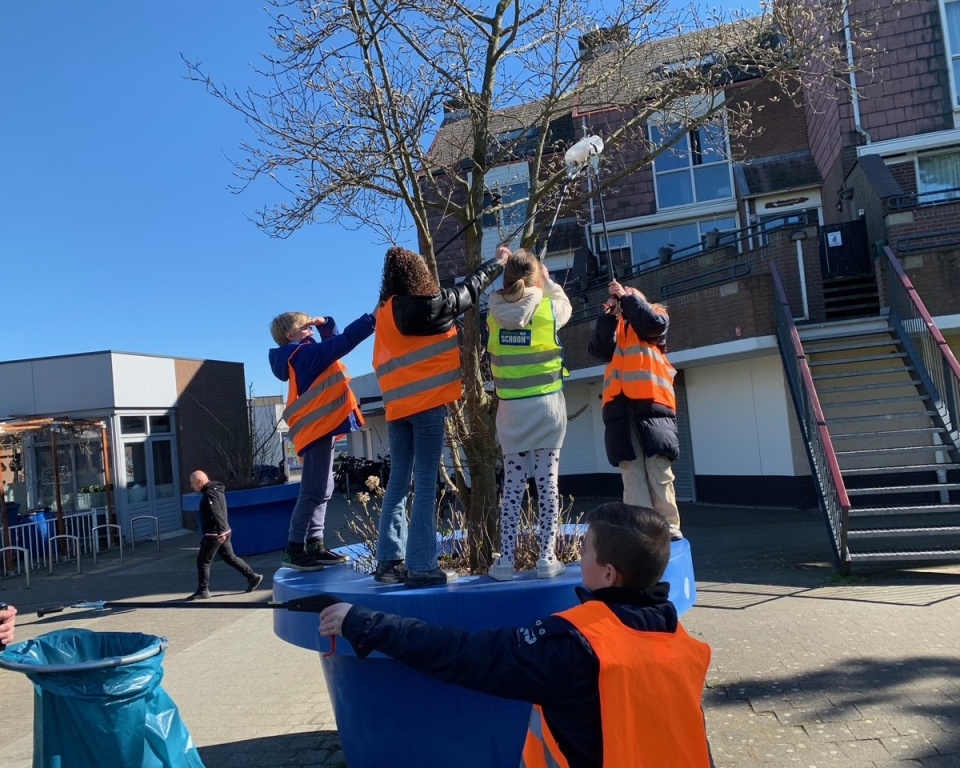 Kinderen halen afval uit een boom