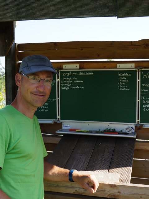 Remko Boers staat naast het bord met groenten die geoogst kunnen worden