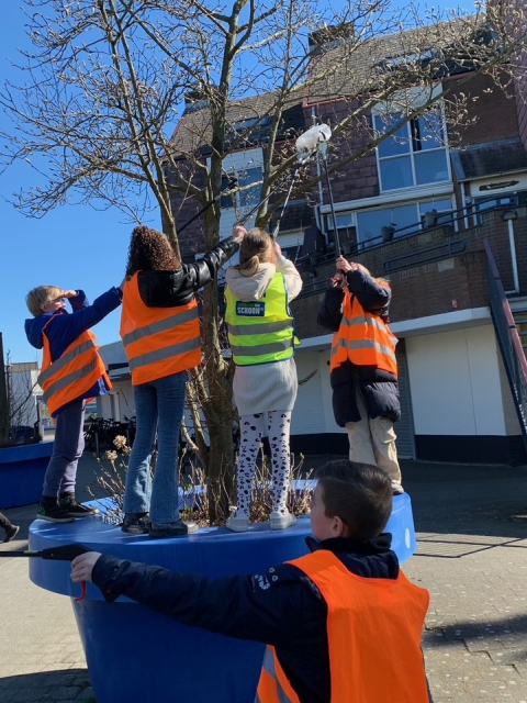 Kinderen halen afval uit een boom