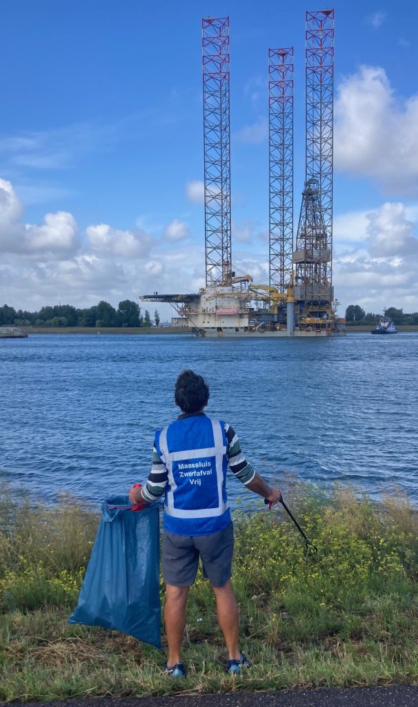 Man ruimt zwerfafval op langs de Nieuwe Waterweg
