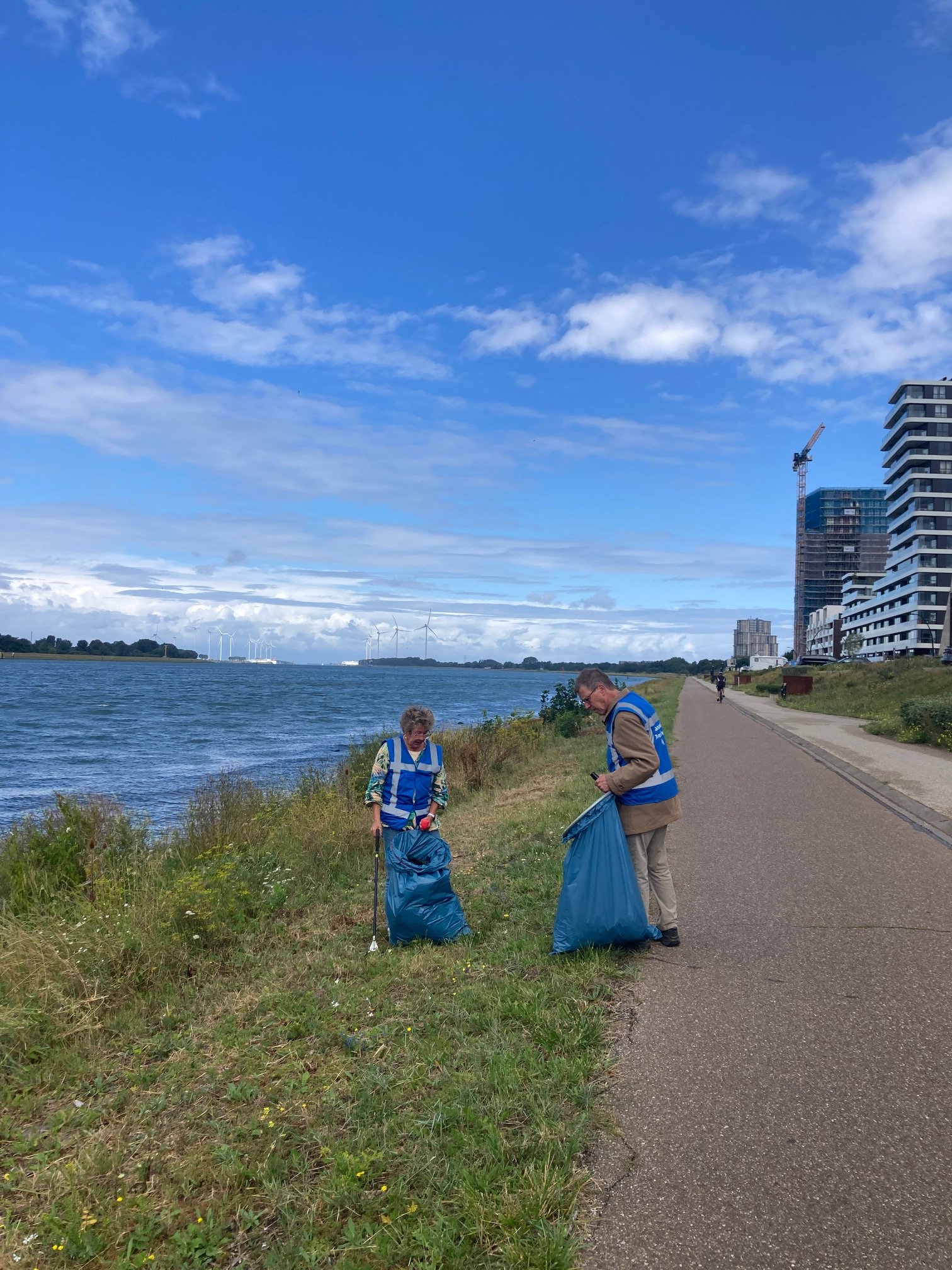 twee personen ruimen zwerfafval op langs de Nieuwe Waterweg