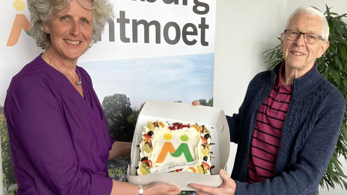Foto van wethouder Willemien Treurniet die een taart overhandigt aan een inwoner