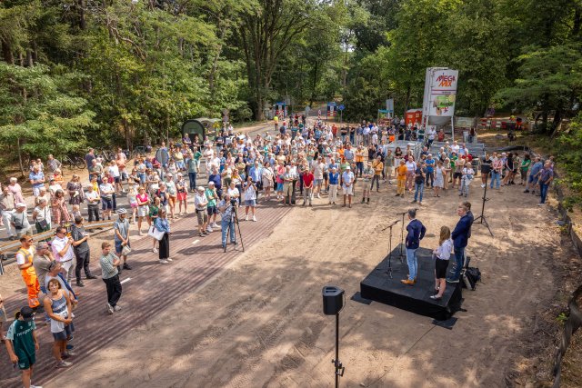 veel mensen hebben zich verzameld en worden toegesproken tijdens de officiële opening van het bruggetje