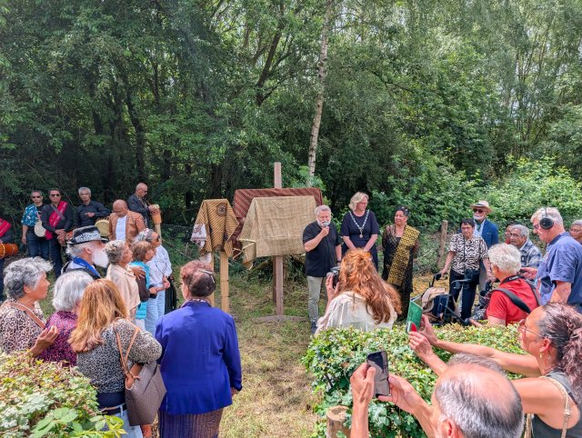 Een groep mensen staat bij elkaar voor de herdenking bij het voormalige Molukse kamp.