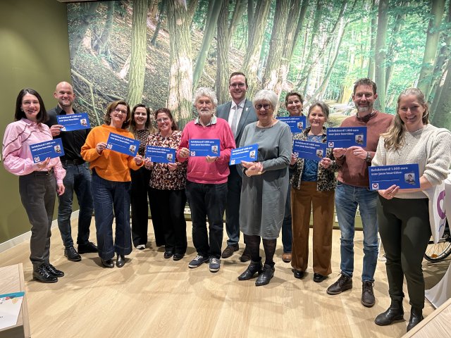 Inwoners tonen in aanwezigheid van wethouder Rodoe de cheque van € 1.000.