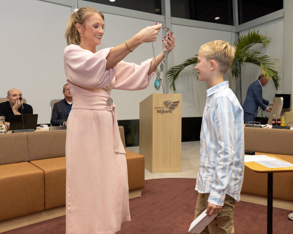 Burgemeester Tinet de Jonge doet de ketting om bij Bram de kinderburgemeester