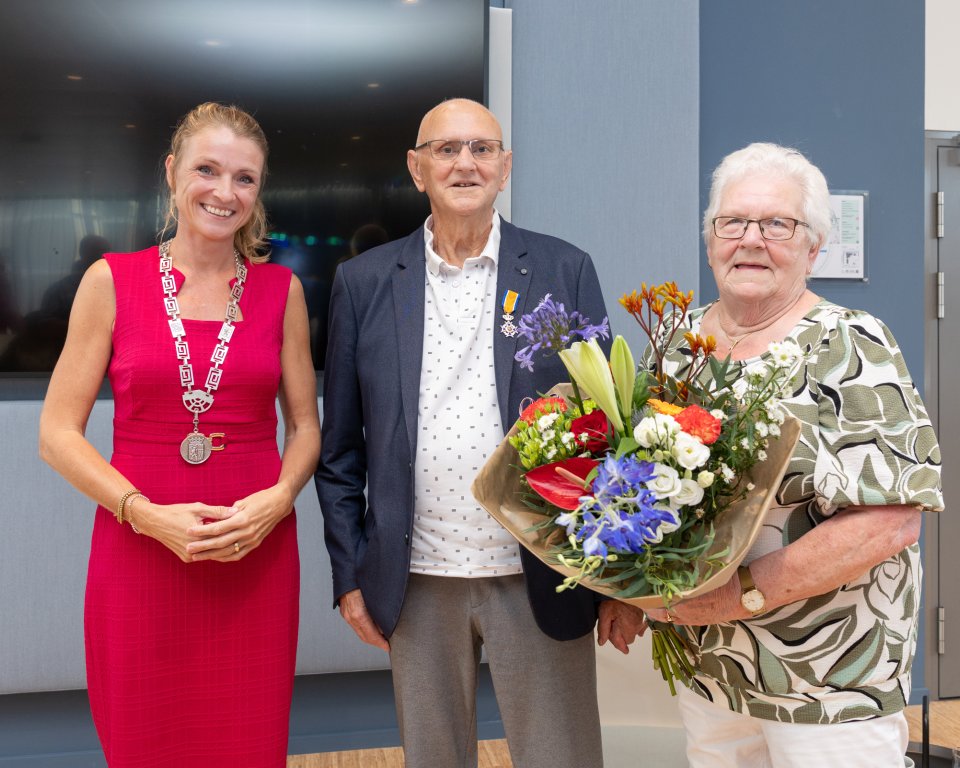 burgemeester met Wim en zijn vrouw met een bos bloemen