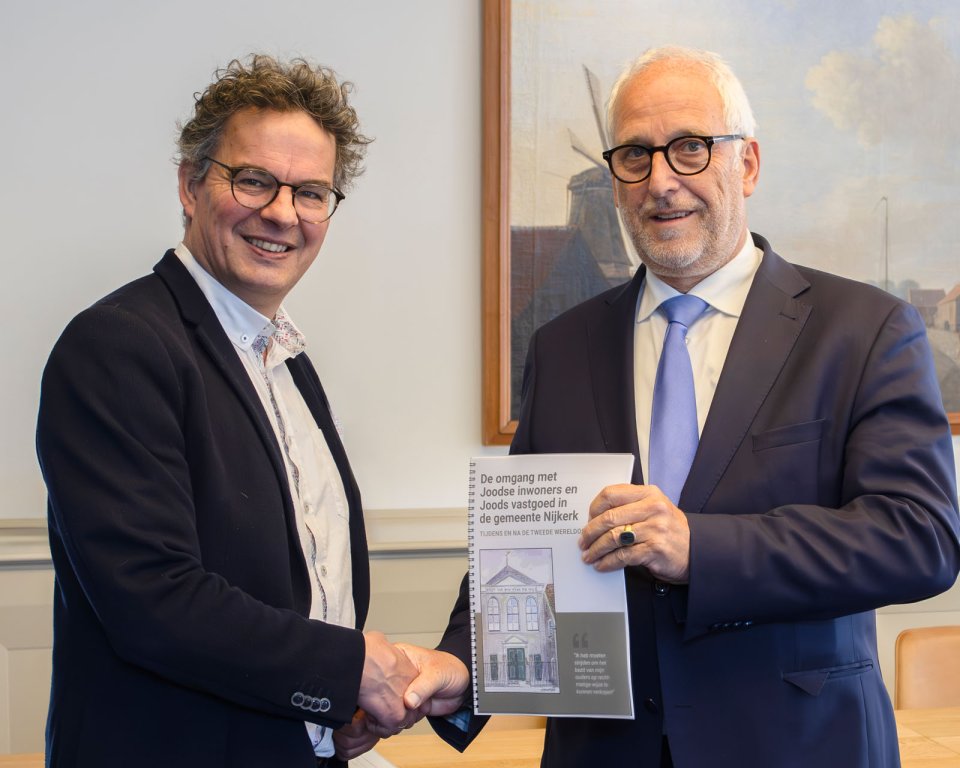 Onderzoeker Anton van Renssen overhandigt rapport aan burgemeester Gerard Renkema.